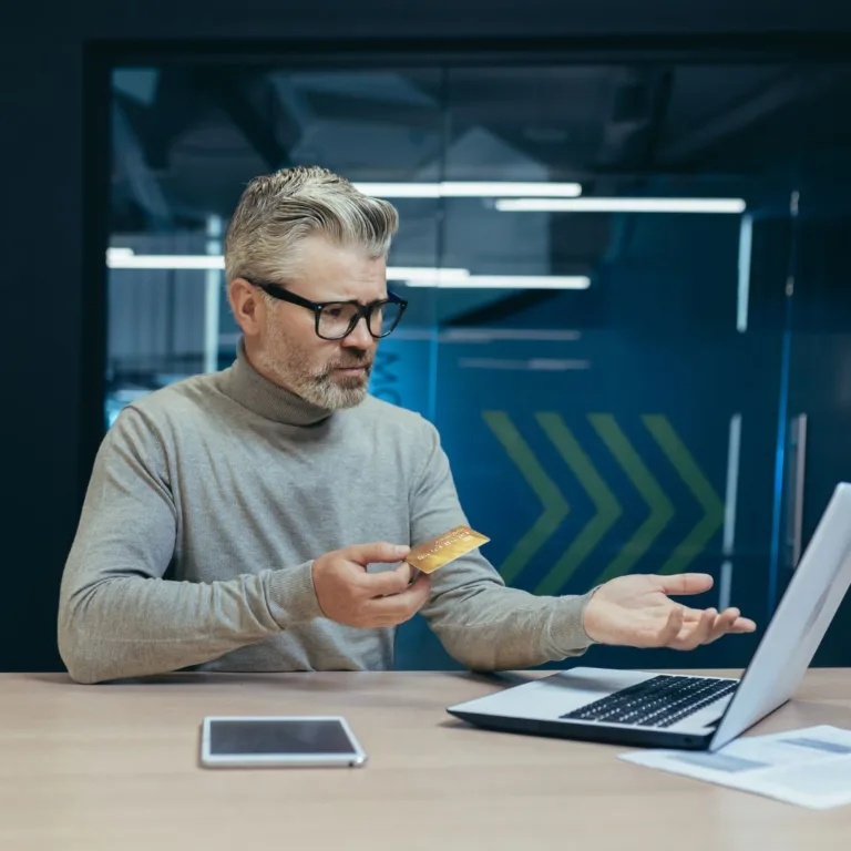 Mężczyzna analizujący swoją sytuację finansową przy laptopie